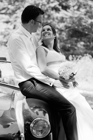 Hochzeitsfotograf, Brautpaar an Auto angelehnt schwarz-weiss