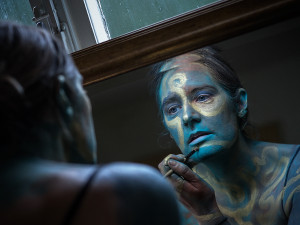 Bodypainting einer Frau beim Bemalen im Spiegel